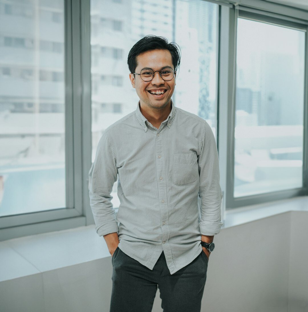 Professional portrait of a Belgian male AI researcher in his 40s with glasses